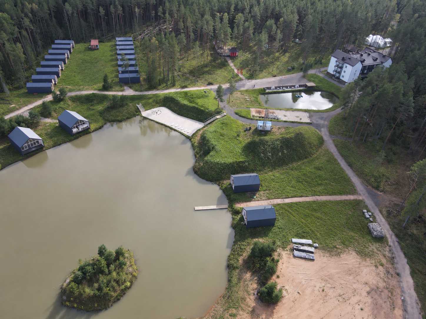 Аэрофотосъёмка территории KAPPINAKI с водоёмами, коттеджами и главным корпусом среди соснового леса